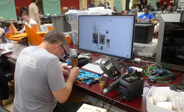 Participants gather for the London Defence Tech Hackathon, a weekend brainstorming solution for technical challenges, at the Royal Military Academy Sandhurst in Camberley, England, May 10, 2025. (AP Photos/Kelvin Chan)