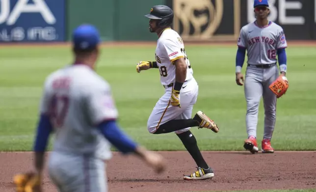 Pittsburgh Pirates' Tommy Pham, center, rounds the bases after hitting a solo home run off New York Mets pitcher Frankie Montas, left, during the first inning of a baseball game in Pittsburgh, Sunday, June 29, 2025. (AP Photo/Gene J. Puskar)