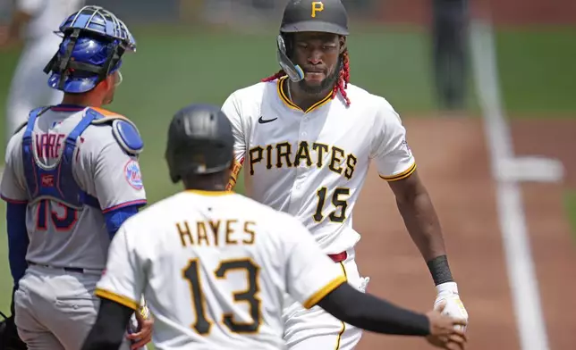 Pittsburgh Pirates' Oneil Cruz (15) is greeted by Ke'Bryan Hayes (13) as he crosses home plate after hitting a two-run home run off New York Mets pitcher Frankie Montas (47) during the first inning of a baseball game in Pittsburgh, Sunday, June 29, 2025. (AP Photo/Gene J. Puskar)