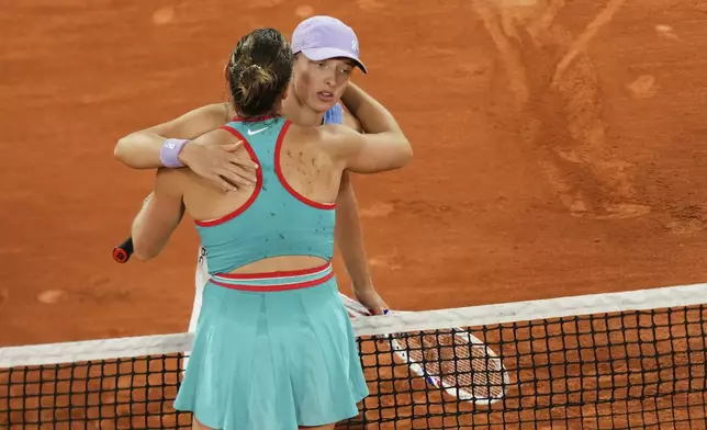 Winner Aryna Sabalenka of Belarus, back to the camera, and Poland's Iga Swiatek hug after their semifinal match of the French Tennis Open at the Roland-Garros stadium in Paris, Thursday, June 5, 2025. (AP Photo/Aurelien Morissard)