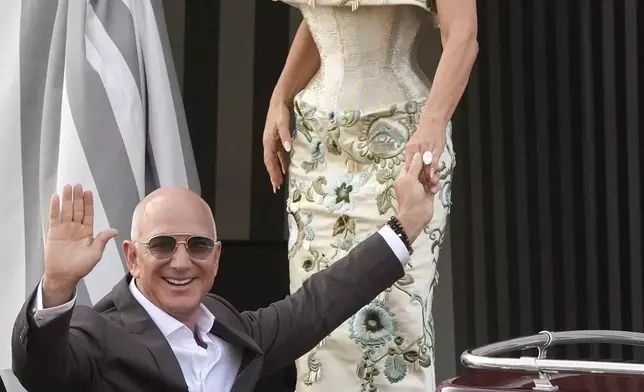 Jeff Bezos, left, and Lauren Sanchez leave a hotel for their pre wedding reception, in Venice, Italy, Thursday, June 26, 2025. (AP Photo/Luca Bruno)