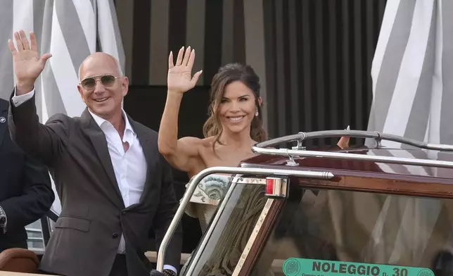 Jeff Bezos, left, and Lauren Sanchez leave a hotel for their pre wedding reception, in Venice, Italy, Thursday, June 26, 2025. (AP Photo/Luca Bruno)