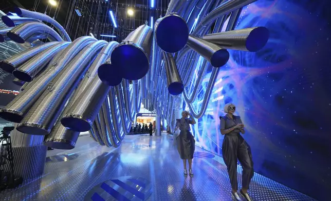 Guests and participants walk inside an exhibition on the sidelines of the St. Petersburg International Economic Forum in St. Petersburg, Russia, Wednesday, June 18, 2025. (AP Photo/Dmitri Lovetsky)