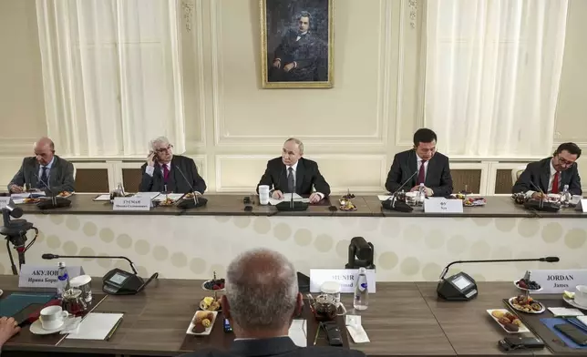 Russian President Vladimir Putin, center, meets with the heads of international news agencies at the newly renovated St. Petersburg Rimsky-Korsakov State Conservatory on the sidelines of the St. Petersburg International Economic Forum in St. Petersburg, Russia, Wednesday, June 18, 2025. (Vyacheslav Prokofyev, Sputnik, Kremlin Pool Photo via AP)