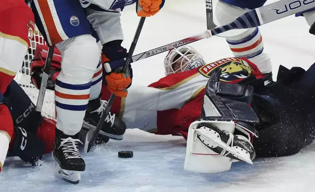 Florida Panthers goalie Sergei Bobrovsky, front right, makes a save against the Edmonton Oilers during the first overtime period in Game 4 of the NHL hockey Stanley Cup Final in Sunrise, Fla., Thursday, June 12, 2025. (Nathan Denette/The Canadian Press via AP)
