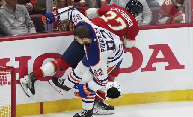 Florida Panthers' Eetu Luostarinen (27) hits Edmonton Oilers' Vasily Podkolzin (92) during the second period in Game 4 of the NHL hockey Stanley Cup Final in Sunrise, Fla., Thursday, June 12, 2025. (Nathan Denette/The Canadian Press via AP)