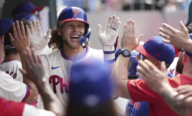 Philadelphia Phillies' Alec Bohm celebrates with teammates after hitting a home run off of Chicago Cubs pitcher Génesis Cabrera during the seventh inning of a baseball game Wednesday, June 11, 2025, in Philadelphia. (AP Photo/Matt Slocum)