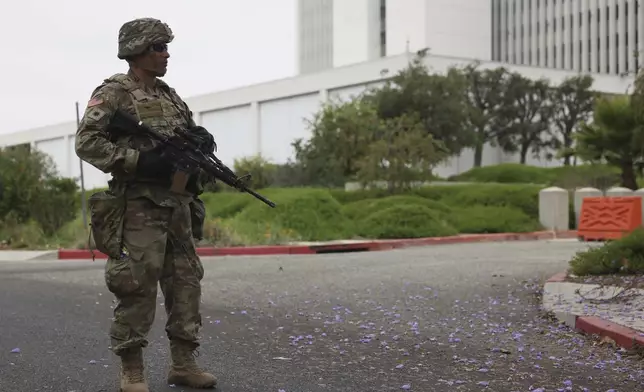 A member of the National Guard stands outside the Wishire Federal building on Thursday, June 12, 2025. (AP Photo/Etienne Laurent)