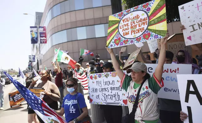 Demonstrators hold signs during a protest, Thursday, June 12, 2025, in Los Angeles. (AP Photo/Etienne Laurent)