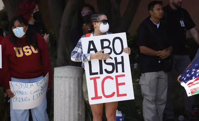 Demonstrators hold signs as they protest, Thursday, June 12, 2025, in Los Angeles. (AP Photo/Etienne Laurent)