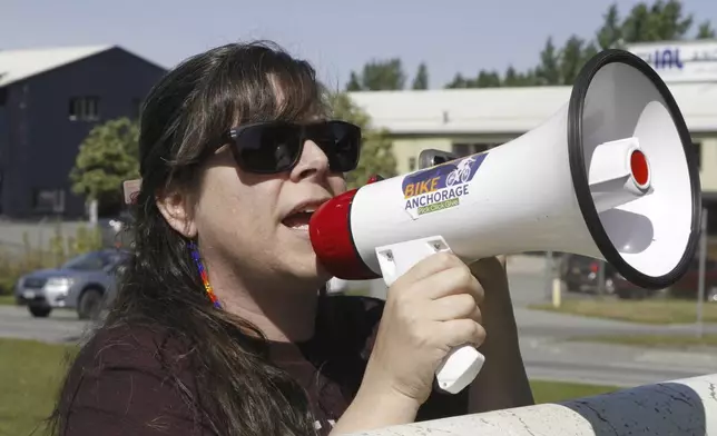 Demonstrator Courtney Moore uses a bullhorn Thursday, June 12, 2025, in Anchorage, Alaska, to protest the detainment of about 40 people being held there under the custody of the Immigration and Customs Enforcement federal agency. (AP Photo/Mark Thiessen)