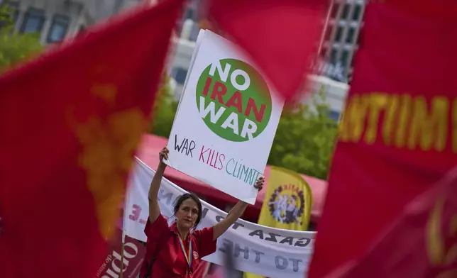 A woman holds a placard during a demonstration ahead of the NATO summit in The Hague, Netherlands, Sunday, June 22, 2025. (AP Photo/Peter Dejong)