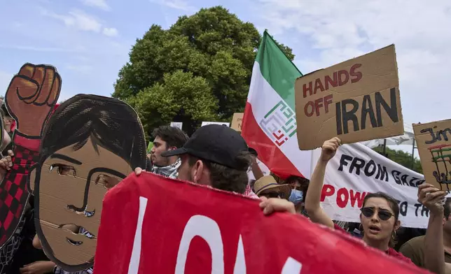 A woman holds a placard during a demonstration ahead of the NATO summit in The Hague, Netherlands, Sunday, June 22, 2025. (AP Photo/Peter Dejong)