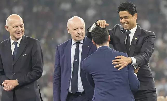 PSG president Nasser Al-Khelaifi, right, hugs Former PSG player Javier Pastore at the end of the Champions League final soccer match between Paris Saint-Germain and Inter Milan at the Allianz Arena in Munich, Germany, Saturday, May 31, 2025. (AP Photo/Martin Meissner)