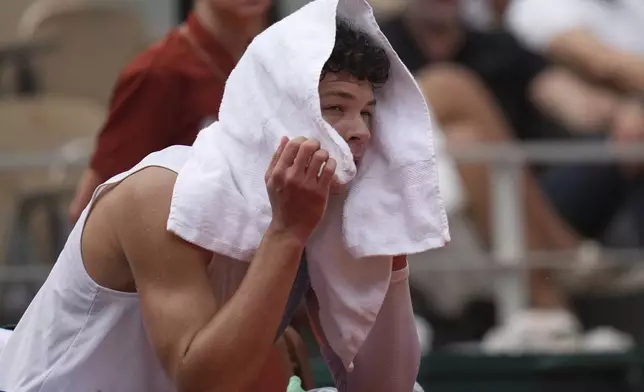 Ben Shelton of the U.S. sits during a break as he plays Spain's Carlos Alcaraz during their fourth round match of the French Tennis Open, at the Roland-Garros stadium, in Paris, Sunday, June 1 2025. (AP Photo/Christophe Ena)