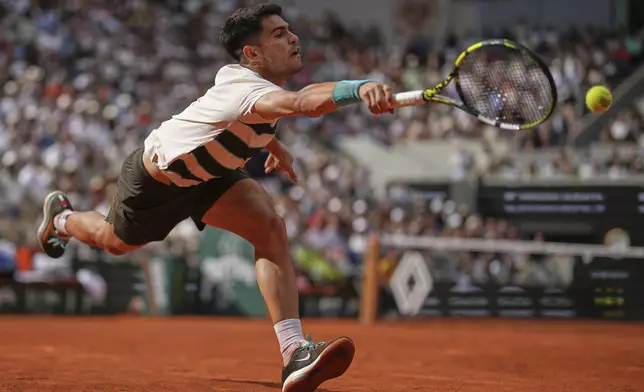 Spain's Carlos Alcaraz returns the ball to Ben Shelton of the U.S. during their fourth round match of the French Tennis Open, at the Roland-Garros stadium, in Paris, Sunday, June 1 2025. (AP Photo/Christophe Ena)
