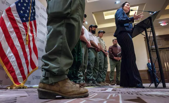 Secretary of Agriculture Brooke Rollins, right, with Forest Service Firefighters behind her, talks to media during the Western Governors Association meeting in Santa Fe, N.M., Monday, June 23, 2025. (Eddie Moore/The Albuquerque Journal via AP)