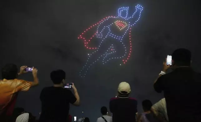 A crowd records a drone show during an event in Pasig city, Philippines on Wednesday June 18, 2025 as part of the upcoming "Superman" movie world tour making it's first stop in the country. (AP Photo/Aaron Favila)