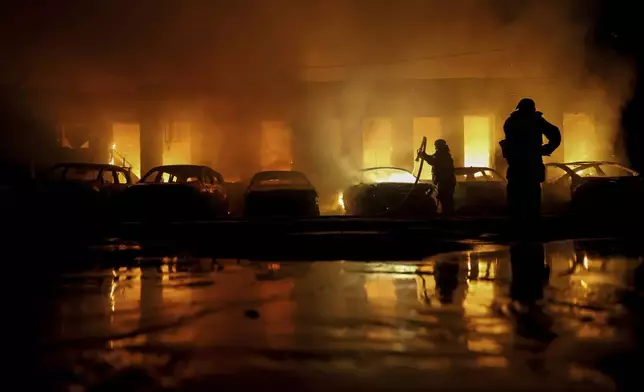 Rescue workers put out a fire of cars destroyed by a Russian drone strike in Zaporizhzhia, Ukraine, on Wednesday, June 18, 2025. (AP Photo/Kateryna Klochko)