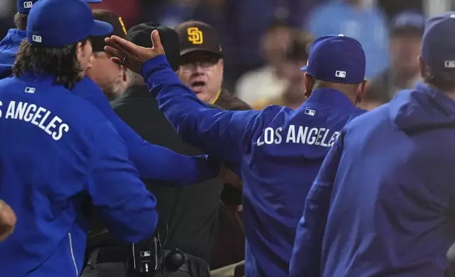 San Diego Padres manager Mike Shildt, center, and Los Angeles Dodgers manager Dave Roberts yell at each other after Padres' Fernando Tatis Jr. was hit by a pitch during the ninth inning of a baseball game Thursday, June 19, 2025, in Los Angeles. (AP Photo/Mark J. Terrill)