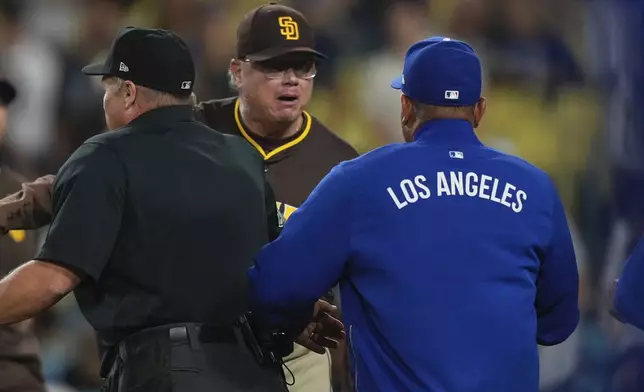 San Diego Padres manager Mike Shildt, center, and Los Angeles Dodgers manager Dave Roberts yell at each other after Padres' Fernando Tatis Jr. was hit by a pitch during the ninth inning of a baseball game Thursday, June 19, 2025, in Los Angeles. (AP Photo/Mark J. Terrill)