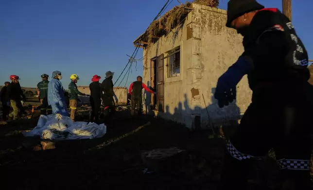 Forensic workers retrieve bodies of a mother and three daughters inside a one room house after floods swept through the area in Mthatha, South Africa, Thursday, June 12, 2025. (AP Photo/Themba Hadebe)