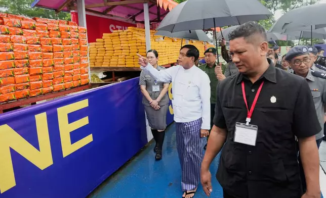 Yangon region Chief Minister Soe Thein, second left in white cloth, inspects seized illegal narcotics during a destruction ceremony to mark International Day against Drug Abuse and Illicit Trafficking, on the outskirts of Yangon, Myanmar, Thursday, June 26, 2025. (AP Photo/Thein Zaw)