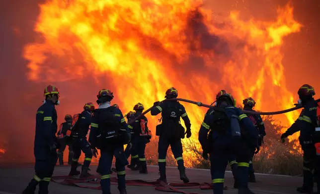 Firefighters battle with a large wildfire burning in Karyes village, on the eastern Aegean island of Chios, Greece, Sunday, June 22, 2025. (Pantelis Fykaris/Politischios.gr via AP)