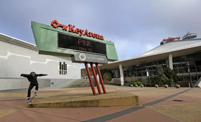 FILE - A skateboarder leaps onto a platform in front of KeyArena, a sports and entertainment venue and former home of the Seattle SuperSonics NBA basketball tean, Dec. 4, 2017, in Seattle. (AP Photo/Elaine Thompson, File)