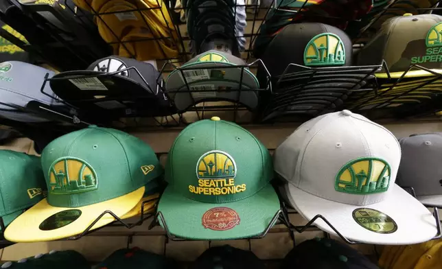 FILE - Stacks of Seattle SuperSonics caps are displayed in a shop, Wednesday, May 15, 2013 in Seattle, near where a proposed basketball arena is to be built. (AP Photo/Elaine Thompson, File)