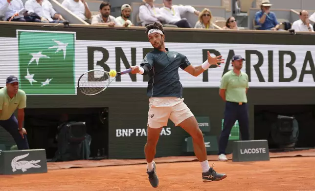 Italy's Lorenzo Musetti plays a shot against Frances Tiafoe of the U.S. during their quarterfinal match of the French Tennis Open at the Roland-Garros stadium in Paris, Tuesday, June 3, 2025. (AP Photo/Aurelien Morissard)