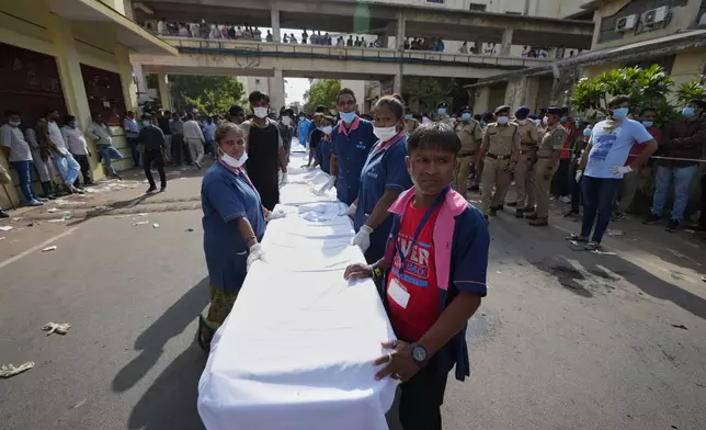 Workers of Civil Hospital wait to receive remains of victims of an airplane that crashed in India's northwestern city of Ahmedabad in Gujarat state, Thursday, June 12, 2025. (AP Photo/Ajit Solanki)
