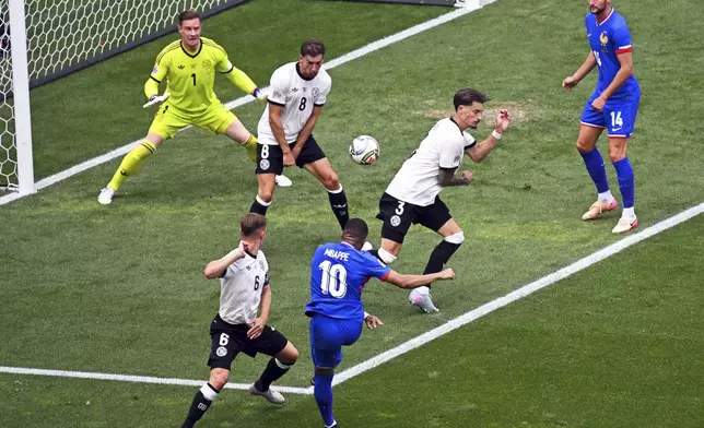 France's Kylian Mbappe, front right, scores the opening goal during the Nations League third place soccer match between Germany and France in Stuttgart, Germany, Sunday, June 8, 2025. (Marijan Murat/dpa via AP)