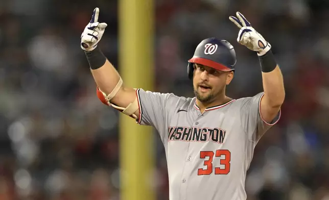 Washington Nationals first baseman Nathaniel Lowe gestures to the dugout after hitting a RBI double during the eighth inning of a baseball game against the Los Angeles Angels, Friday, June 27, 2025, in Anaheim, Calif. (AP Photo/Jayne Kamin-Oncea)