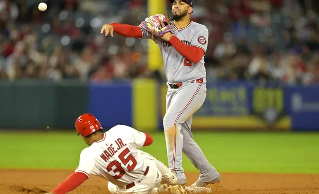 Los Angeles Angels' LaMonte Wade Jr. (35) is out at second as Washington Nationals second baseman Luis Garcia Jr. throws to first during the eighth inning of a baseball game Friday, June 27, 2025, in Anaheim, Calif. (AP Photo/Jayne Kamin-Oncea)