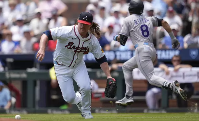 Atlanta Braves pitcher Grant Holmes (66) attempts fielding a ball hit by Colorado Rockies' Ryan Ritter (8) in the third inning of a baseball game, Sunday, June 15, 2025, in Atlanta. (AP Photo/Mike Stewart)