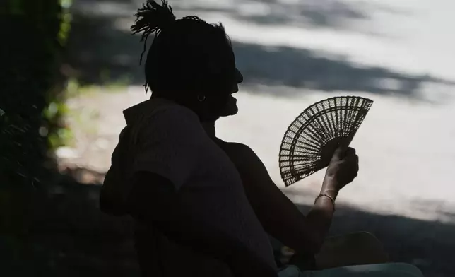 A man rests in the Retiro park in Madrid, Spain, Saturday, June 28, 2025. (AP Photo/Paul White)