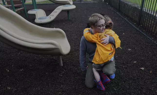 Kirt Ethridge hugs his daughter, Eliza, 5, while at a playground Thursday, April 10, 2025, in Evansville, Ind. (AP Photo/Joshua A. Bickel)