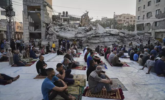 Palestinians gather for Eid al-Adha prayers beside the ruins of a mosque destroyed by Israeli bombardment, in Deir al-Balah, Gaza on Friday, June 6, 2025. (AP Photo/Abdel Kareem Hana)