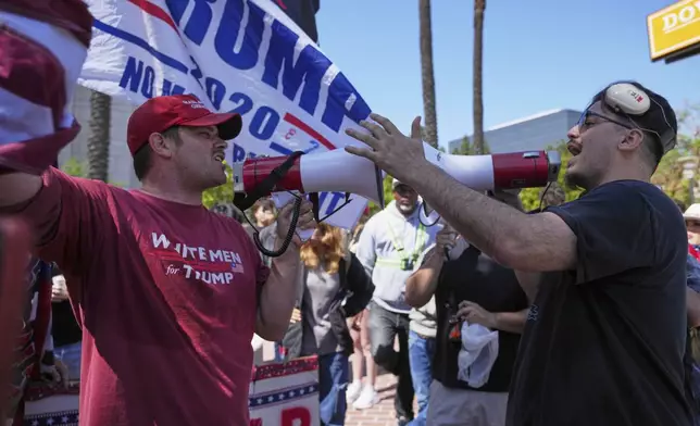 A protester wearing a shirt reading "WHITE MEN for TRUMP" argues with another protester Tuesday, June 10, 2025, in Santa Ana, Calif. (AP Photo/Jae C. Hong)