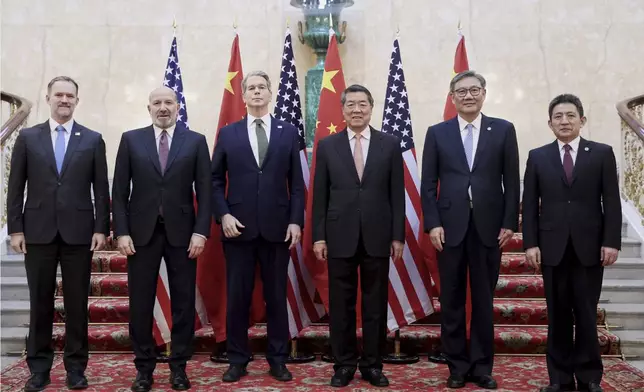 In this photo released by Xinhua News Agency, Chinese Vice Premier He Lifeng, center right, and U.S. Treasury Secretary Scott Bessent, center left, pose for a group photo with delegations before their meeting to discuss China-U.S. trade, in London, Monday, June 9, 2025. (Li Ying/Xinhua via AP)