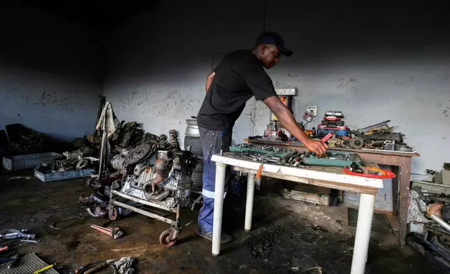 Themba Maseko, a 39-year-old mechanic, works inside his workshop in Brakpan, east of Johannesburg, South Africa, Wednesday, April 30, 2025. (AP Photo/Themba Hadebe)