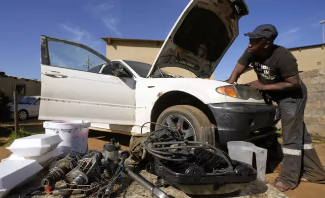 Themba Maseko, a 39-year-old mechanic, repairs a BMW car outside his workshop in Brakpan, east of Johannesburg, South Africa, Wednesday, May 14, 2025. (AP Photo/Themba Hadebe)