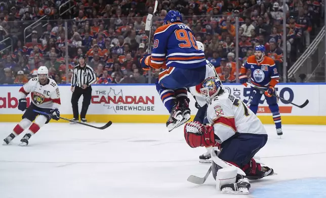 Florida Panthers goalie Sergei Bobrovsky (72) makes the save as Edmonton Oilers' Corey Perry (90) jumps in front of him during the second period in Game 2 of the NHL hockey Stanley Cup Finals, in Edmonton, Alberta, Friday, June 6, 2025. (Darryl Dyck/The Canadian Press via AP)