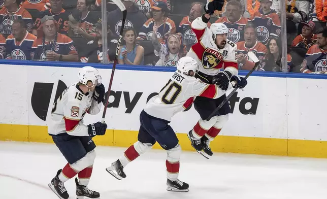Florida Panthers' Brad Marchand (63) celebrates his game-winning goal against the Edmonton Oilers with Jesper Boqvist (70) and Anton Lundell (15) during the second overtime period in Game 2 of the NHL Stanley Cup final in Edmonton, Friday, June 6, 2025. (Jason Franson/The Canadian Press via AP)
