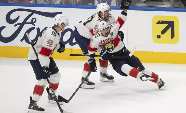 Florida Panthers' Brad Marchand (63) celebrates his game-winning goal against the Edmonton Oilers with Jesper Boqvist (70) and Anton Lundell (15) during the second overtime period in Game 2 of the NHL Stanley Cup final in Edmonton, Friday, June 6, 2025.(Jason Franson/The Canadian Press via AP)