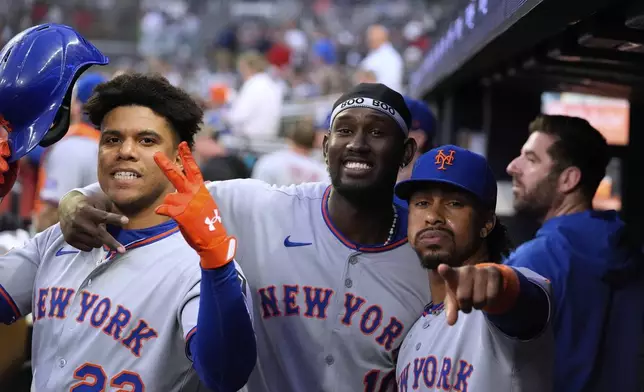 New York Mets' Juan Soto, left, Ronny Mauricio, middle, and Francisco Lindor, right, celebrate Soto's solo home run in the first inning of a baseball game against the Atlanta Braves, Tuesday, June 17, 2025, in Atlanta. (AP Photo/Brynn Anderson)