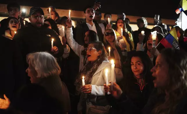 People hold candles as they gather outside the clinic where Colombian Senator Miguel Uribe Turbay is being treated after he was shot at a political rally, in Bogota, Colombia, Sunday, June 8, 2025. (AP Photo/Ivan Valencia)