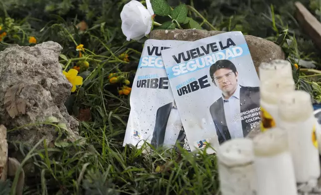 Images of Colombian Senator Miguel Uribe Turbay, along with candles and flowers, lay at the site where he was shot during a political rally in Bogota, Colombia, Monday, June 9, 2025. (AP Photo/John Vizcaino)