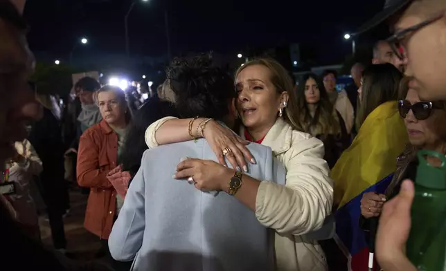 People hug each other outside the clinic where Colombian Sen. Miguel Uribe Turbay is being treated after he was shot at a political rally, in Bogota, Colombia, Sunday, June 8, 2025. (AP Photo/Ramon Espinosa)